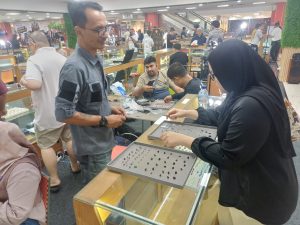 Pengunjung (tengah) melihat batu permata pada salah satu stand pameran batu permata di Pasar Pagi Mangga Dua, Jakarta Utara, Sabtu (8/8/2026). (Foto: Harnas.co.id/Aria Triyudha)